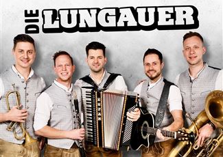 A live band is playing on a stage in the mountains. In the background, there are snow-covered peaks and spectators enjoying the concert.