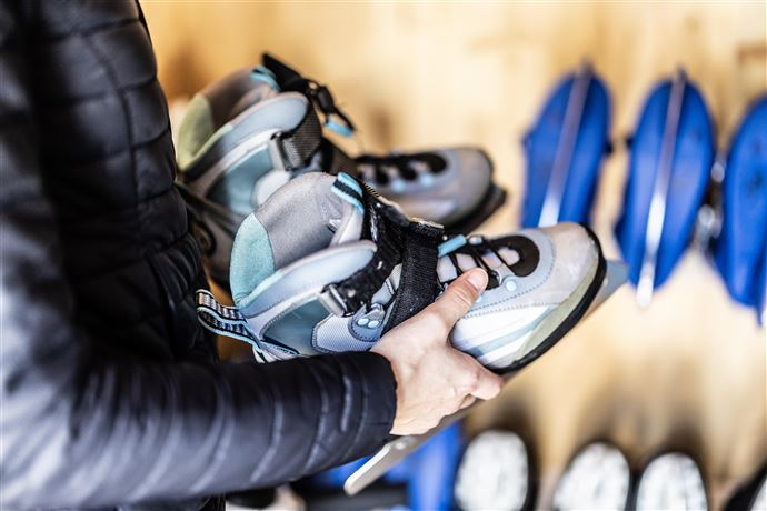 A modern, illuminated swimming pool in the mountains at night. Surrounded by snow and decorative lights, it offers a relaxing atmosphere.
