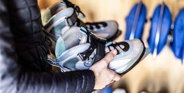 A modern, illuminated swimming pool in the mountains at night. Surrounded by snow and decorative lights, it offers a relaxing atmosphere.