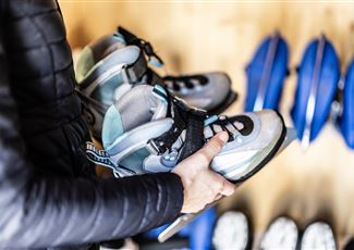 A modern, illuminated swimming pool in the mountains at night. Surrounded by snow and decorative lights, it offers a relaxing atmosphere.