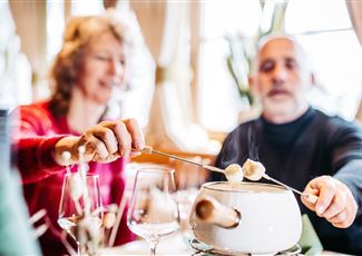 Ein Paar genießt ein Fondue in einem gemütlichen Restaurant. Die Atmosphäre ist entspannt und einladend.