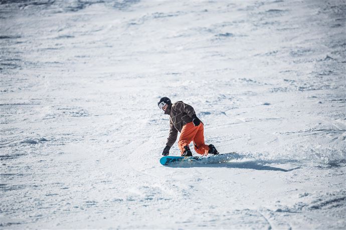 Eine lebhafte Veranstaltung in einer modernen Halle mit einer Band auf der Bühne. Die Menge jubelt und genießt die Musik.