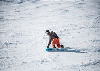 Eine lebhafte Veranstaltung in einer modernen Halle mit einer Band auf der Bühne. Die Menge jubelt und genießt die Musik.
