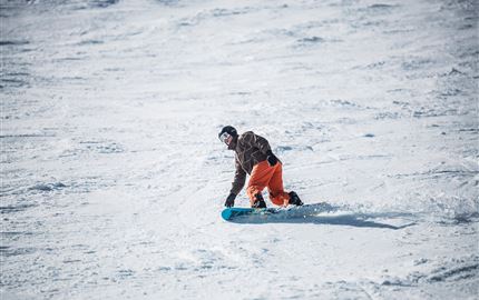 Eine lebhafte Veranstaltung in einer modernen Halle mit einer Band auf der Bühne. Die Menge jubelt und genießt die Musik.