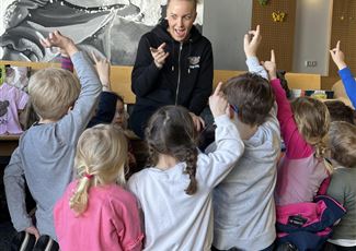 Eine Puppenbühne mit bunten Marionetten und einer dekorativen Kulisse. Kinder schauen fasziniert zu.
