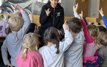 Eine Puppenbühne mit bunten Marionetten und einer dekorativen Kulisse. Kinder schauen fasziniert zu.