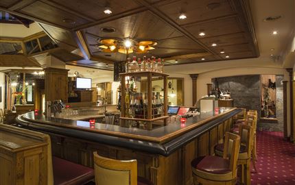 A snowy landscape with a small village and a church. In the background, majestic mountains rise.