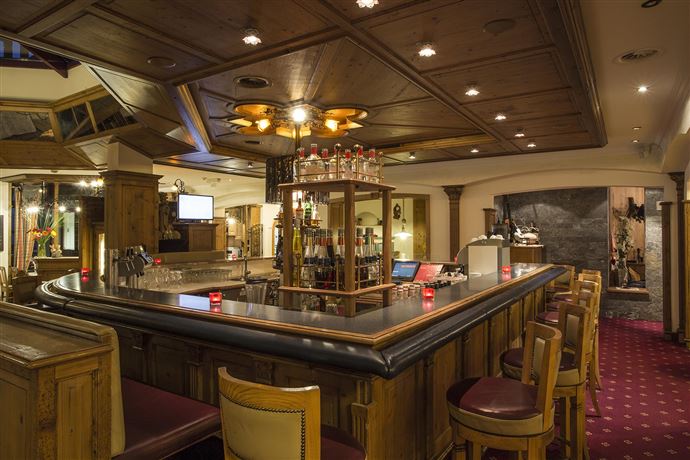 Eine verschneite Landschaft mit einem kleinen Dorf und einer Kirche. Im Hintergrund erheben sich majestätische Berge.