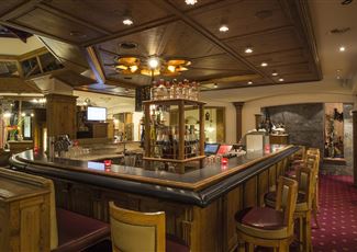 Eine verschneite Landschaft mit einem kleinen Dorf und einer Kirche. Im Hintergrund erheben sich majestätische Berge.