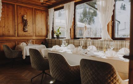 Ein gemütliches Restaurant mit Holzvertäfelung und großen Fenstern. Die Tische sind elegant gedeckt und laden zum Entspannen ein.