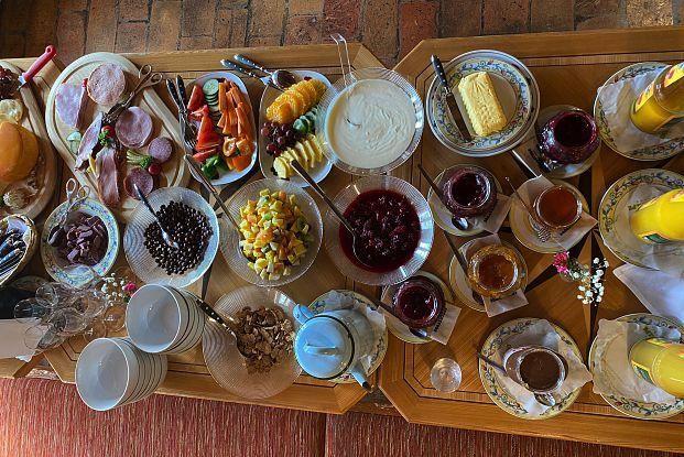 Ein reichhaltiges Frühstücksbuffet mit verschiedenen Speisen wie Aufschnitt, Obst, Joghurt und Marmelade. Die Vielfalt an Gerichten bietet eine bunte Auswahl für jeden Geschmack.