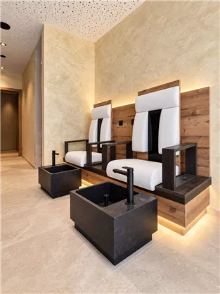 An elegant spa area with two modern foot massage chairs. The combination of wood and soft light accents creates a relaxing atmosphere.