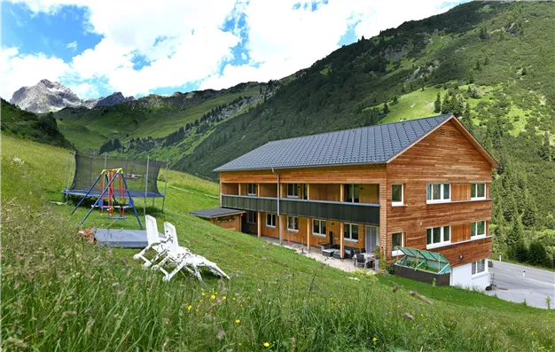 Haus mit Spielplatz und Grillplatz im Hintergrund
