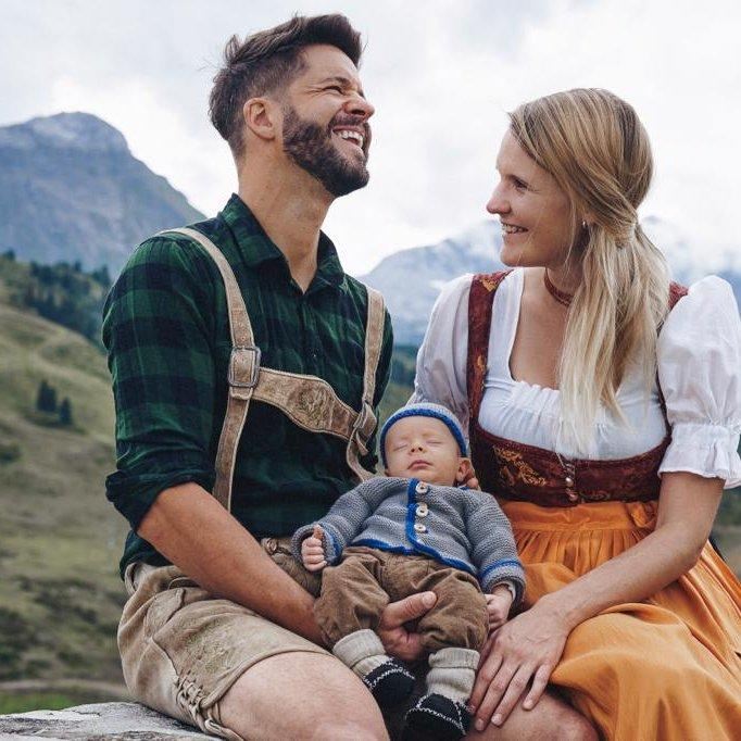 A family – mom, dad, and baby – in traditional attire.